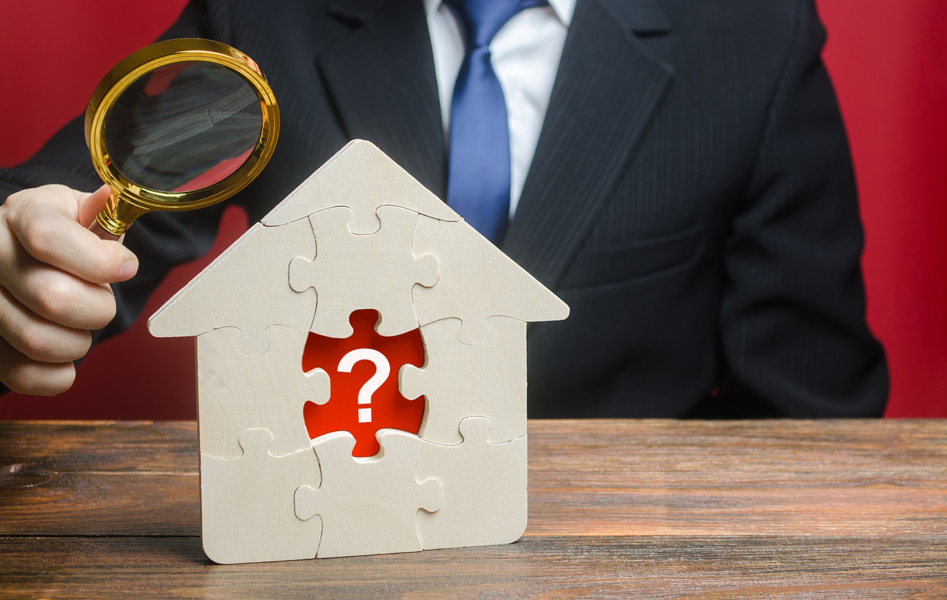 A man examines a house with a missing puzzle inside. Property valuation. Finding problems and structural hidden defects. Checking for compliance with the parameters criteria. Solving housing problems